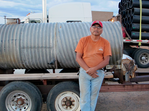 Edward Bennett, a Navajo rancher, leans against his water tank at the Shell Gas Station in Page, Arizona. With no running water for his family or his livestock, Bennett fills up the tank at least twice a day. (Photo by Charlotte Weiner/GroundTruth)