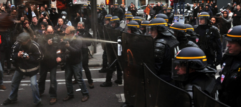 riot police spray protesters in paris
