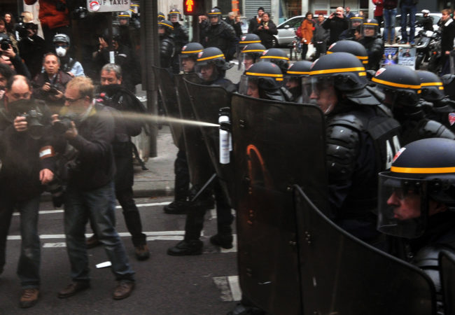 riot police spray protesters in paris