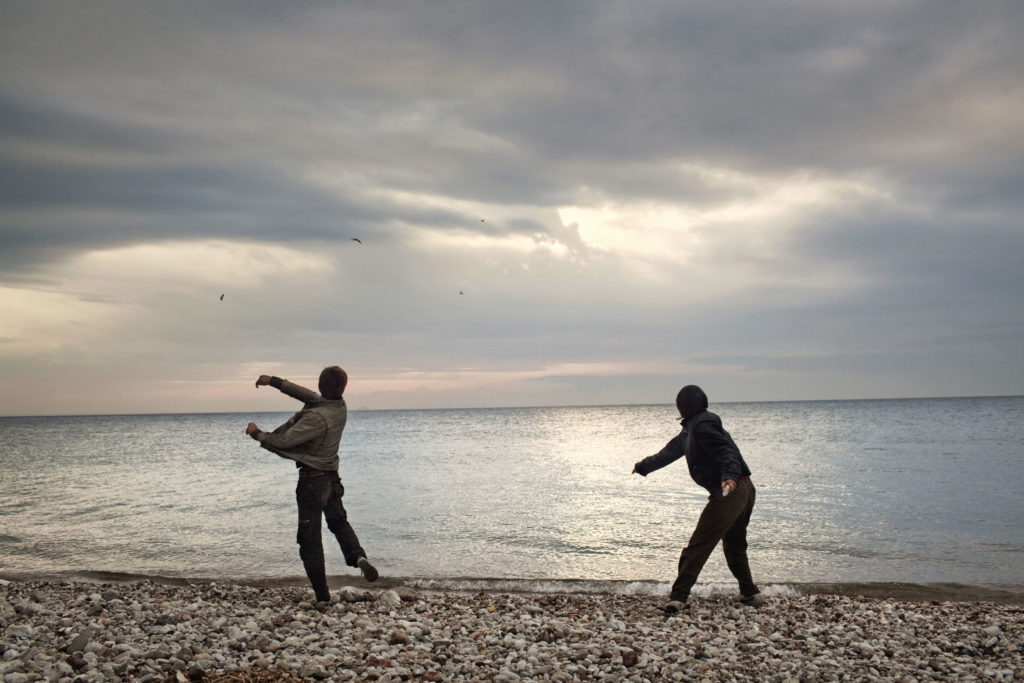 In Patras, Greece Afghan boys throw stones into the sea. They were waiting for evening, when they were going to try to sneak into the port, where they hoped to illegally board a ship bound for Italy. Patras is one of the main escape points from Greece, due to the numerous cargo ships that dock in the port and are bound for Italy. YOUTH DENIED: Young migrants try to reach Europe In Greece, more than 99.5% (2012) of requests for political asylum were refused, and for this reason, these young people are forced to hide from the authorities, because having a Greek police record would mean the end of the dream of safe reception in Europe. This is the story of young, unaccompanied migrants in Greece: young people who, every day, confront the difficulties of a country consumed by an economic crisis. Greece also refuses asylum requests more than any other country in Europe. Many young migrants therefore see other European countries as their only hope for future, and attempt to leave Greece at the first possible moment, often in desperate ways, while tolerating horrible living conditions.