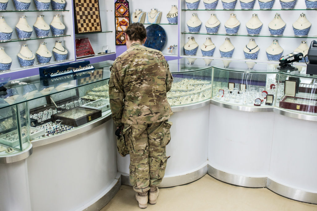 A soldier at Kandahar Airfield shops for jewelry on the 10-year-old store's last day of business. (Photo by Ben Brody)