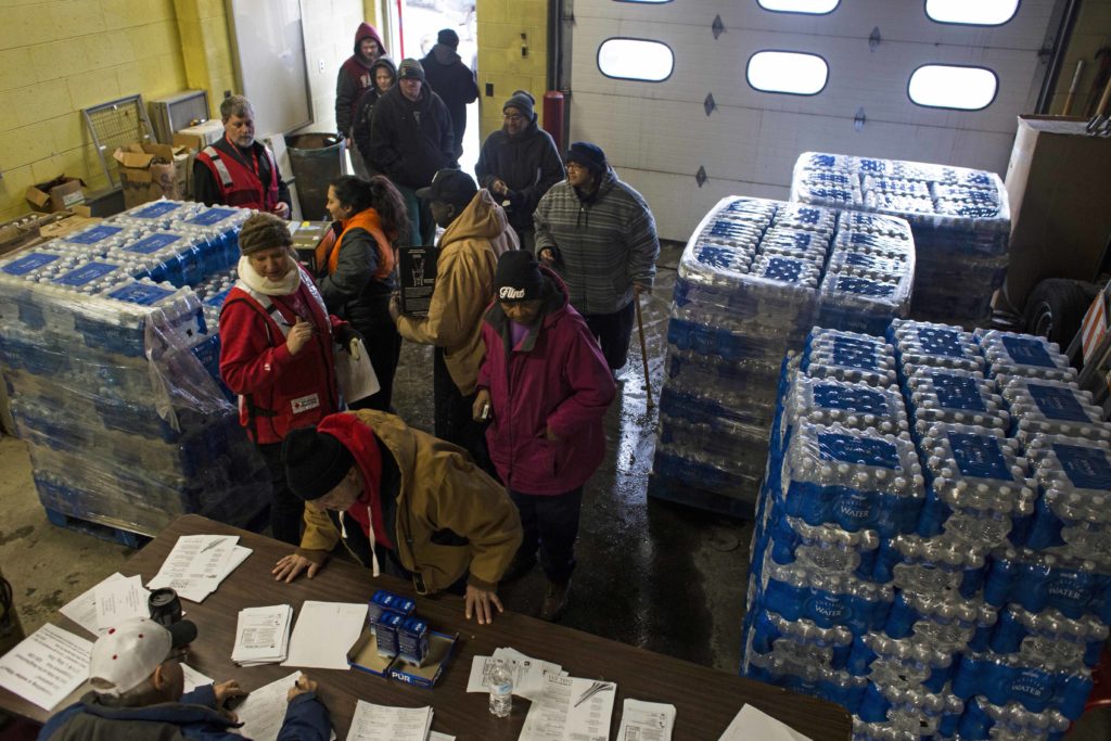 Local residents wait in line to pick up Brita water filters at the Flint Fire Department in downtown Flint on January 15, 2016. Following the declaration for a state of emergency, local fire stations began acting as water resource centers, where residents could pick up water filters, lead testing kits and cases of bottled water. (Brittany Greeson/GroundTruth)