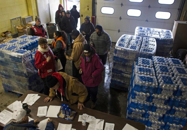 Local residents wait in line to pick up Brita water filters at the Flint Fire Department in downtown Flint on January 15, 2016. Following the declaration for a state of emergency, local fire stations began acting as water resource centers, where residents could pick up water filters, lead testing kits and cases of bottled water. (Brittany Greeson/GroundTruth)