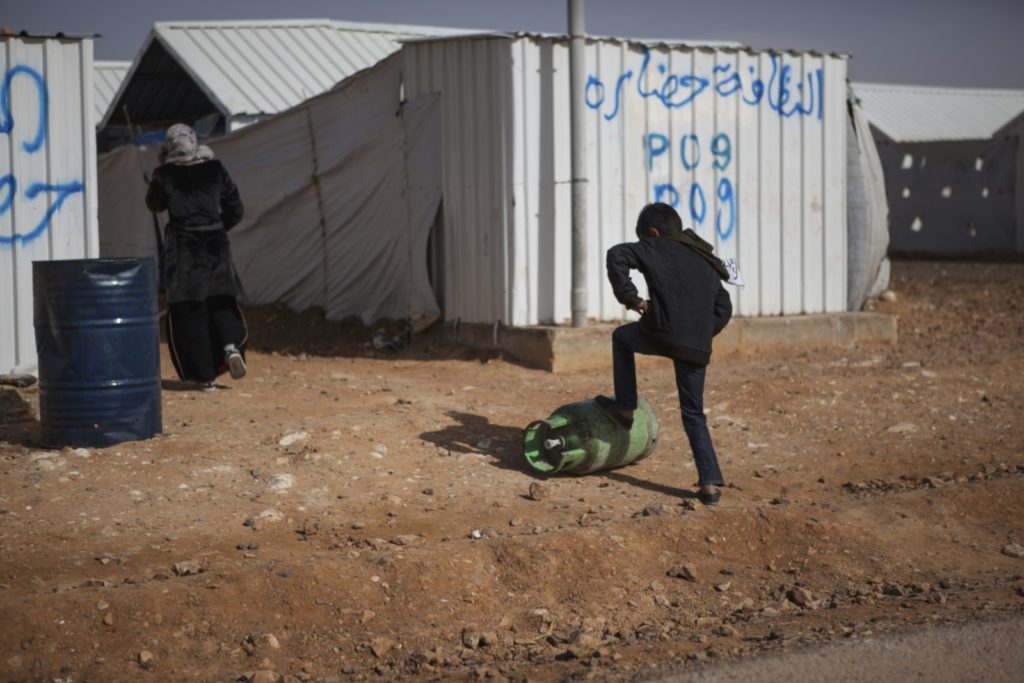 Azraq, Jordan January 19, 2016 - A young boy pushed a gas tank up a street in Azraq refugee camp. Opened in April 2014 to house the overflow of refugees arriving in Jordan, Azraq refugee camp stands mostly empty only filling approximately 18,000 of its 130,000 capacity. This creates problems with acquiring funding and further NGO assistance. Credit: Christopher Lee