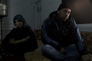 Abu Mohammad (right), sat with his wife, Um Mohammad (left) in their improvised tented settlement in the Bekaa Valley. Out of fear for their teenaged daughter's safety, the Abu Mohammad, arranged her to be married at the age of 13. Unfortunately, Batoul, the daughter, is suffering from domestic violence and is not allowed to move or live freely. (Photo by Christopher Lee/GroundTruth)