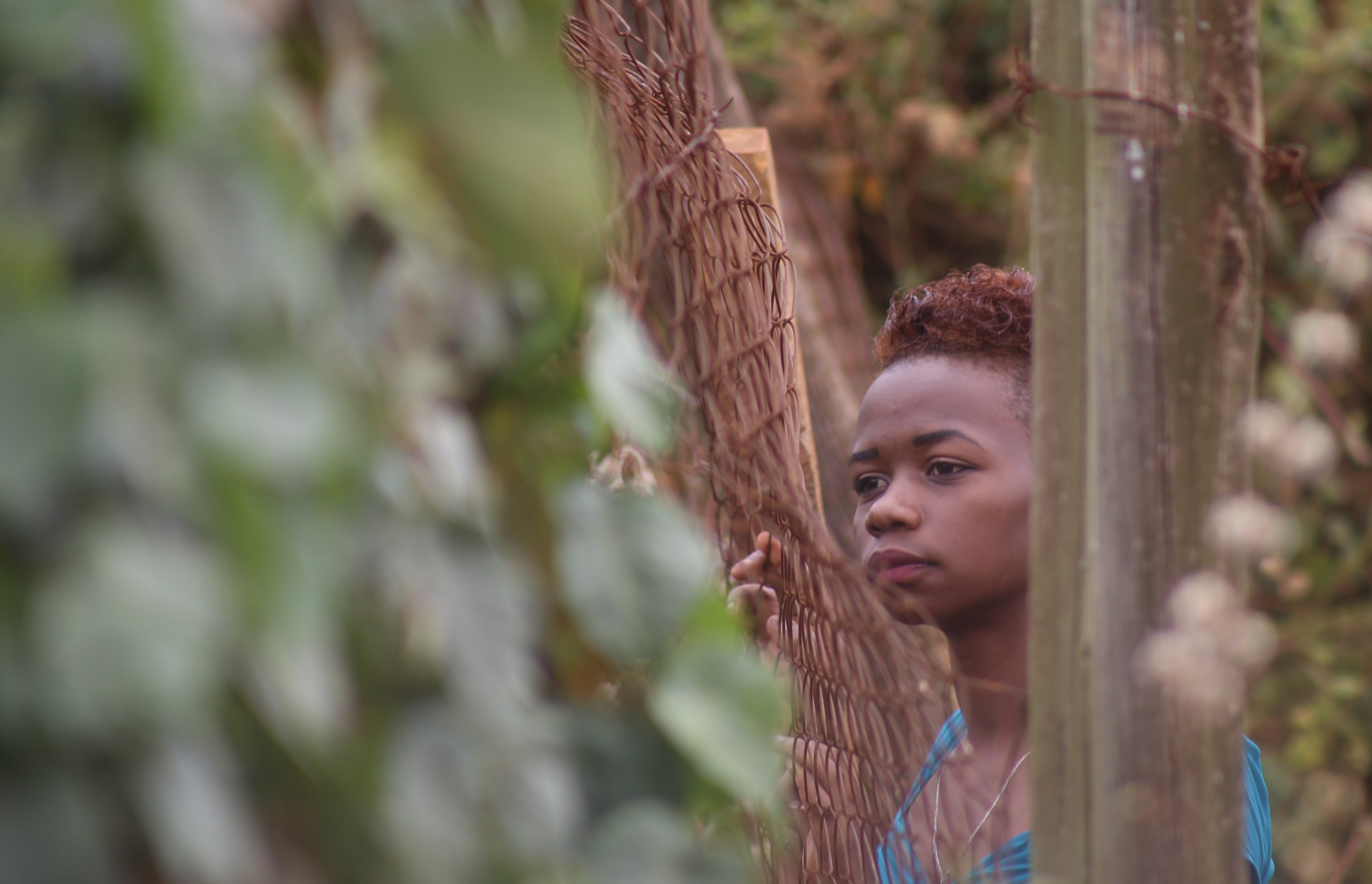 Sandra Gituchu along the perimeter fence of her residence at Moi University. She is among the Garissa University terror attack survivors who transferred to Moi last year. She now obsesses about her escape route in case of another attack by al-Shabaab. (Billy Mutai/GroundTruth)