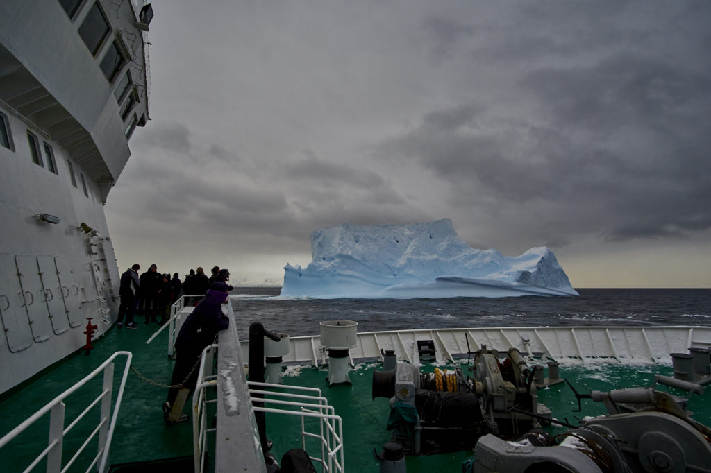 Members of the International Antarctic Expedition 2016 watch as they pass by an iceberg. (Photo by Oliver Wheeldon/2041 Foundation)