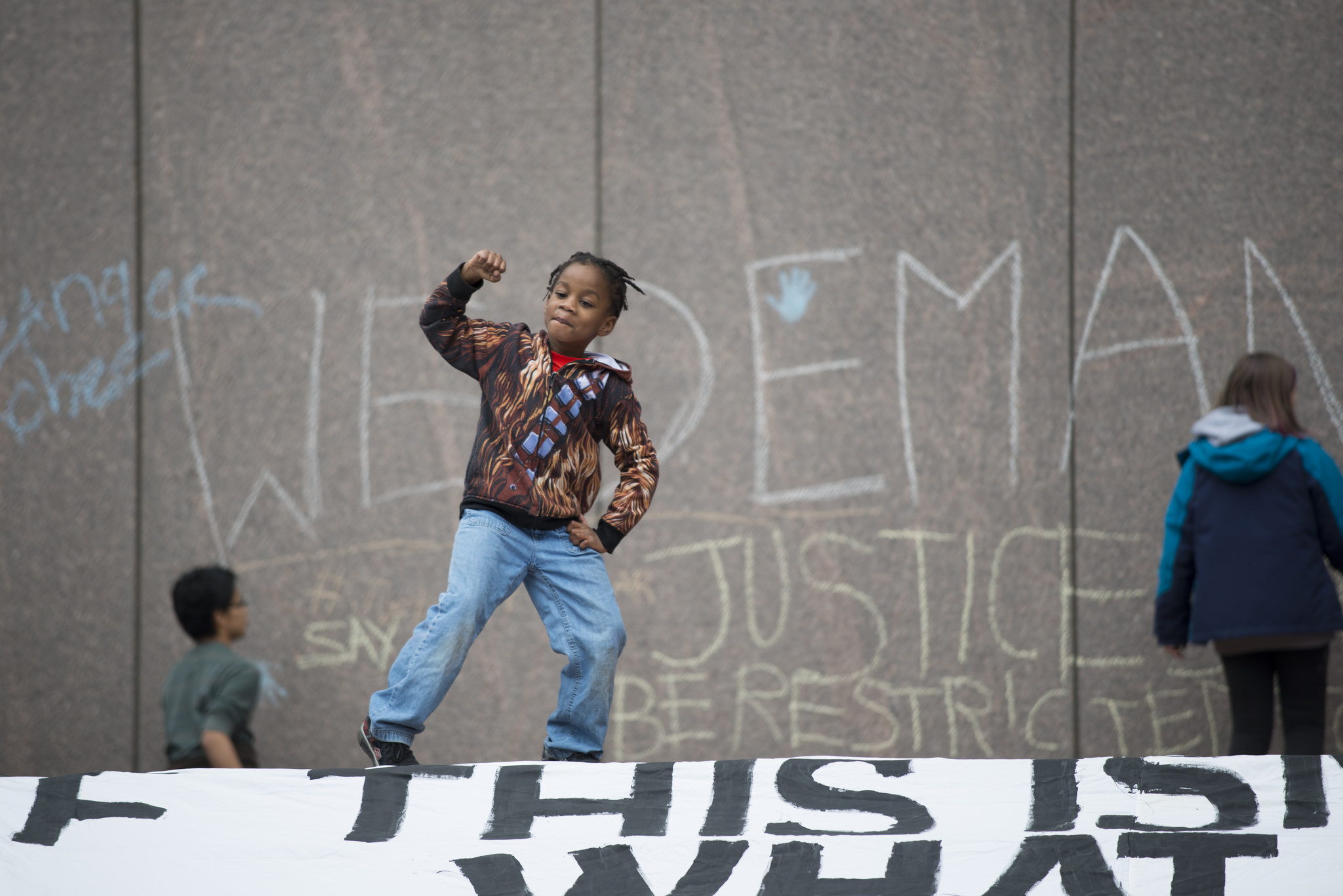 A young boy raises his fist at a protest against the police killing of Jamar Clark in Minneapolis. Shortly after 24-year-old Clark's death, the hashtag #Justice4Jamar started trending on Twitter. (Photo by Fibonacci Blue/Flickr User)