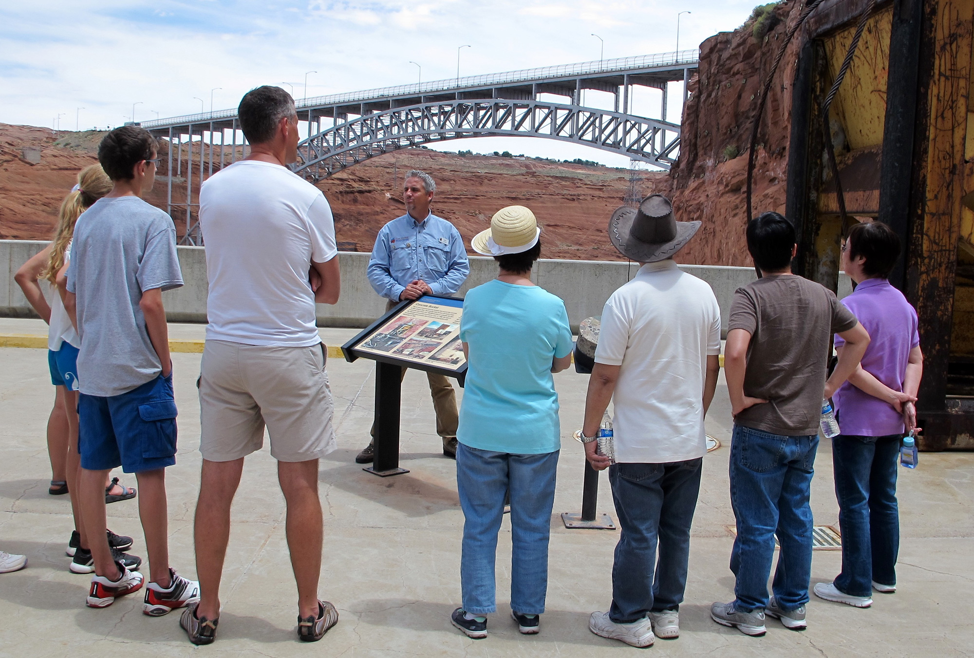 A tour group stands at Glen Canyon Dam, the head of Lake Powell. The dam and the lake it created are at the center of a $250 million dollar tourism industry in Page, Arizona. (Photo by Charlotte Weiner/GroundTruth)