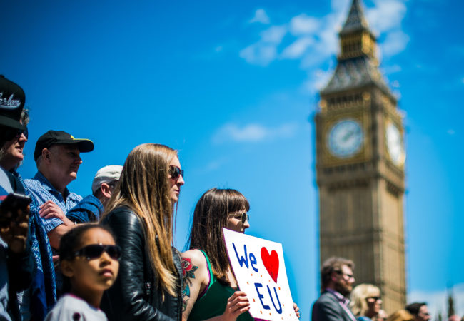 A young woman holds up a sign in favor of the European Union at the 'March for Europe' protest on July 2, London's Big Ben visible in the sky above. (Photo by Garon S/Flickr User)
