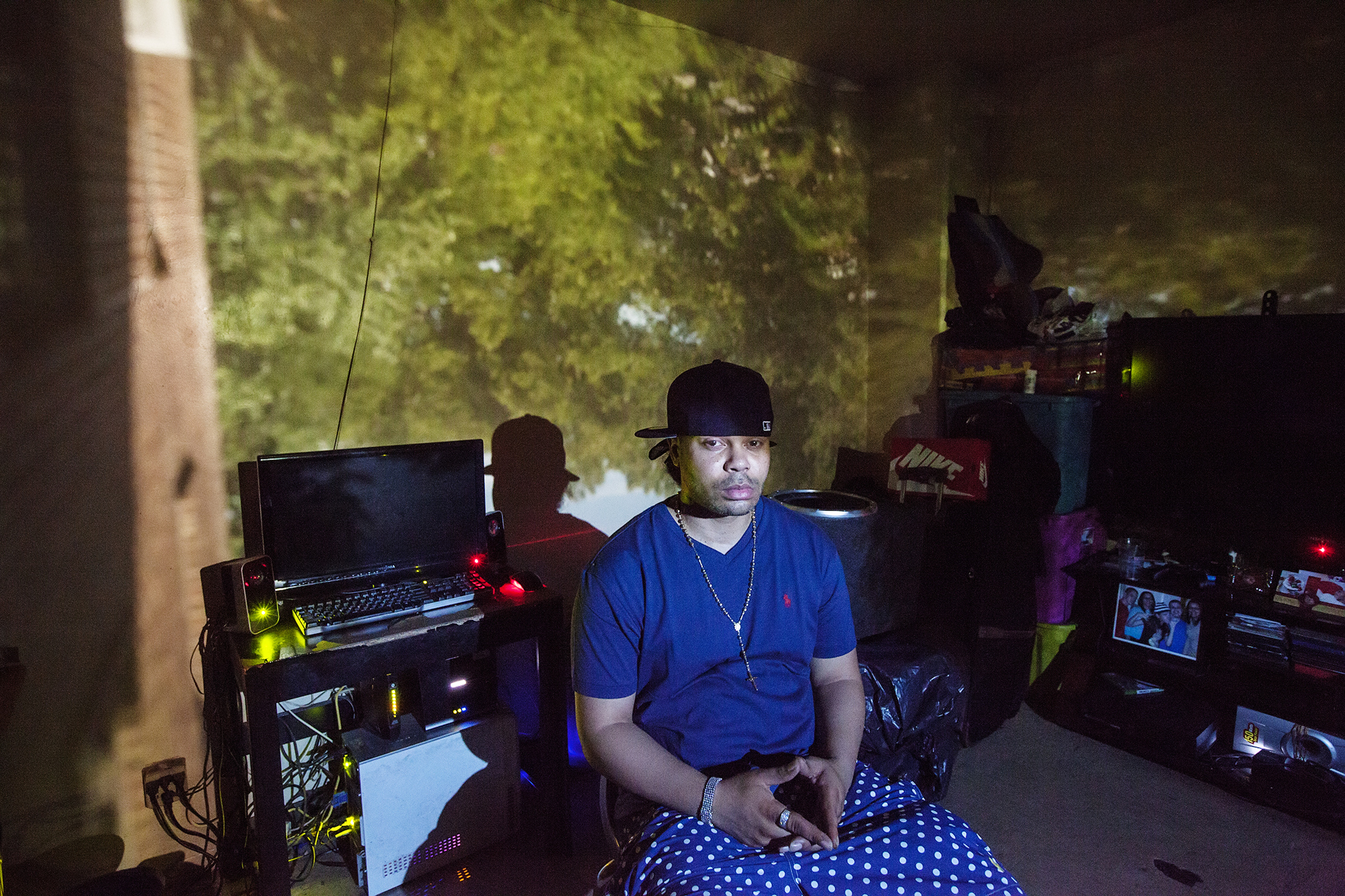 "Boo" poses for a portrait in East New York on July 25, 2015. Raising East New York (RENY) is a portraiture project about Black fathers where the photographer, Phyllis B. Dooney, uses a photographic technique called Camera Obscura to project the outside streets of East New York in the subjects apartment in real time.