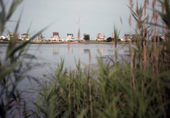 Scituate homes are being raised 16 to 20 feet above sea level to comply with the ‘100-year-storm flood marker,’ a level that fluctuates depending on location. The town offers select grants to homeowners to adapt their homes for flooding through the Federal Hazard Mitigation Grant Program. Financial assistance can provide up to 75 percent of the total cost of the climate mitigation project. (Lauren Owens Lambert/GroundTruth)