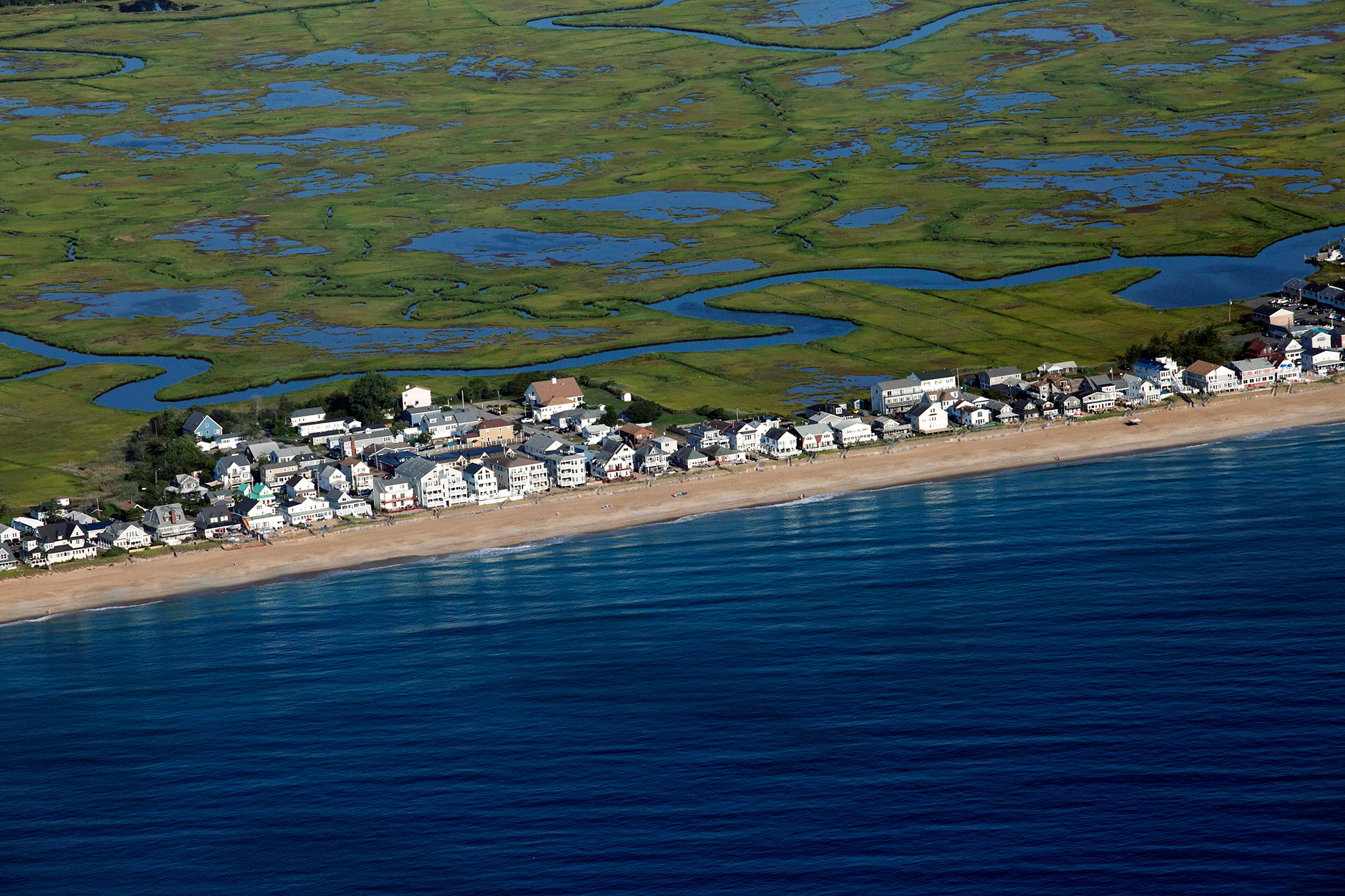 Homes along Salisbury Beach in Massachusetts and neighboring Hampton Beach in New Hampshire face the Atlantic Ocean and are backed by miles of marsh. As sea level rise elevates the water table, flooding can come from the marsh instead of the ocean. (Photo by Lauren Owens Lambert/GroundTruth)