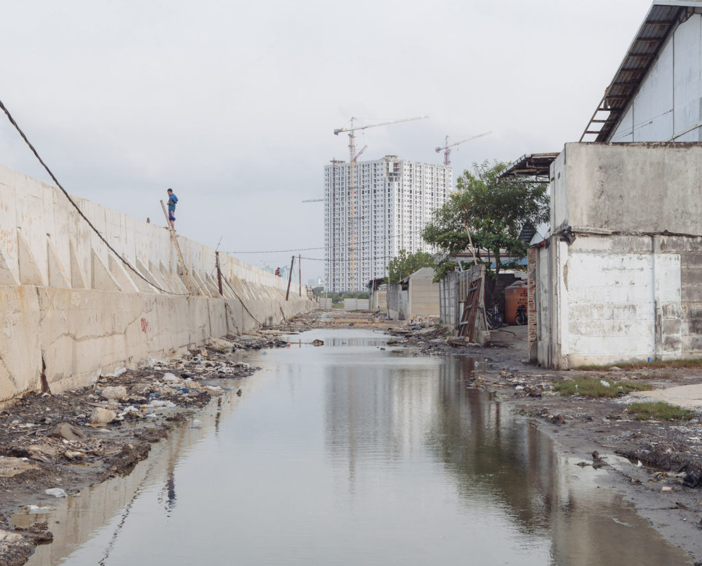 Seawater seeps under a recently reinforced section of seawall in Muara Baru, North Jakarta. This was once a thriving area, but it's now abandoned. (Photo by Muhammad Fadli)