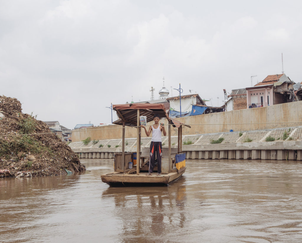 A man on Ciliwung River in Kampung Melayu makes money by offering river crossings to local residents. (Photo by Muhammad Fadli)