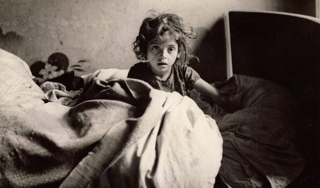 A young female refugee sits up in bed in France, 1940. (Photo by Martha Sharp/Sharp Family Archives)