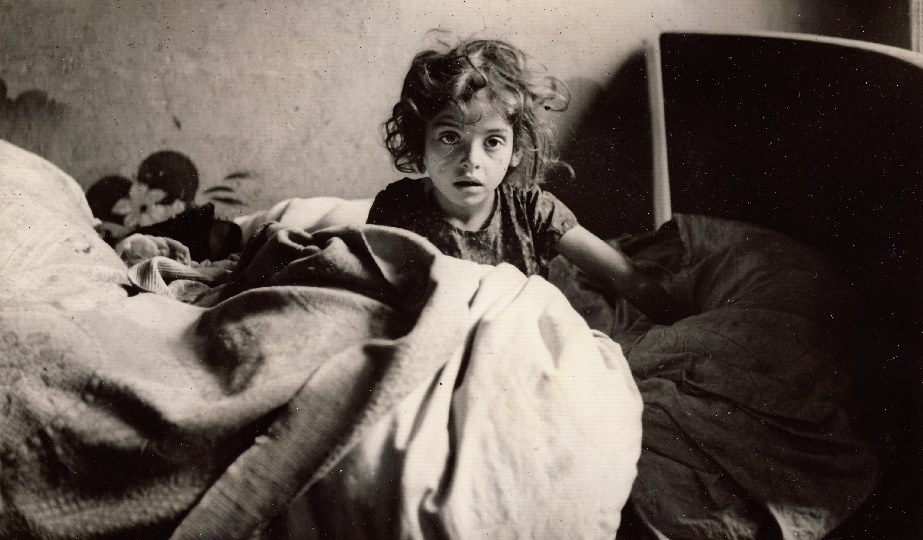 A young female refugee sits up in bed in France, 1940. (Photo by Martha Sharp/Sharp Family Archives)