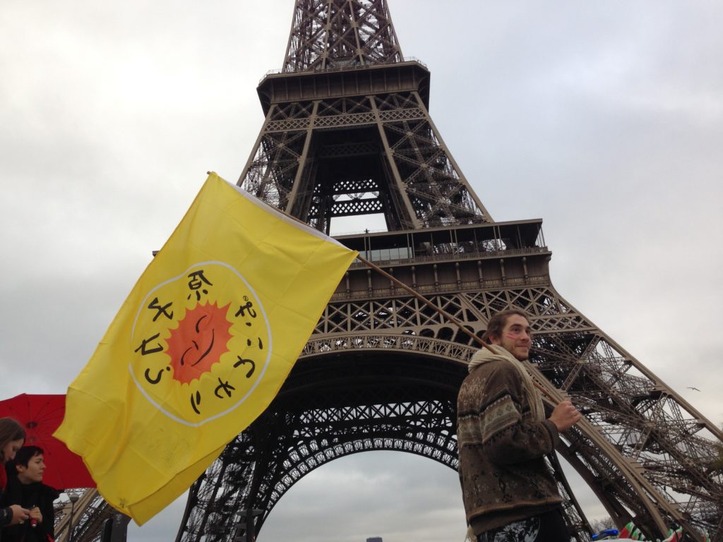A protestor stood in front of the Eiffel Tower during COP21 in Paris, where 195 countries made climate history, adopting an ambitious and unprecedented international plan to limit global warming to below 2 degrees. (Carlos Felipe Pardo/Flickr)