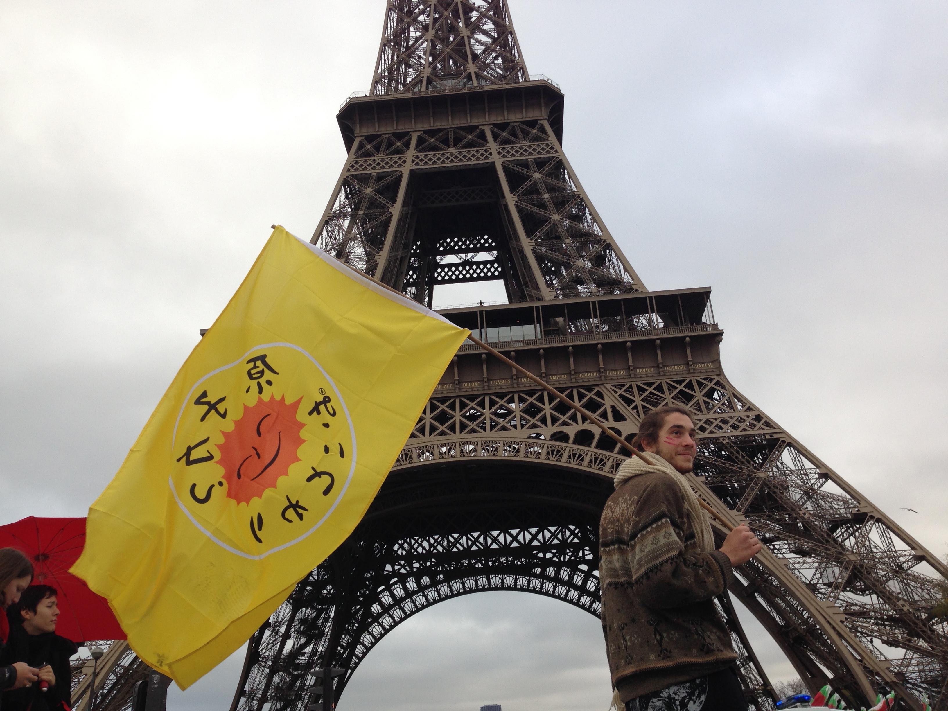 A protestor stood in front of the Eiffel Tower during COP21 in Paris, where 195 countries made climate history, adopting an ambitious and unprecedented international plan to limit global warming to below 2 degrees. (Carlos Felipe Pardo/Flickr)