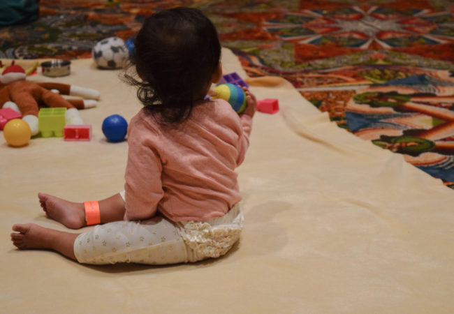 A young child plays under the supervision of childcare workers at the Grace Hopper Celebration of Women in Computing, a renown tech conference. (Photo by Alicia Miles/GroundTruth)