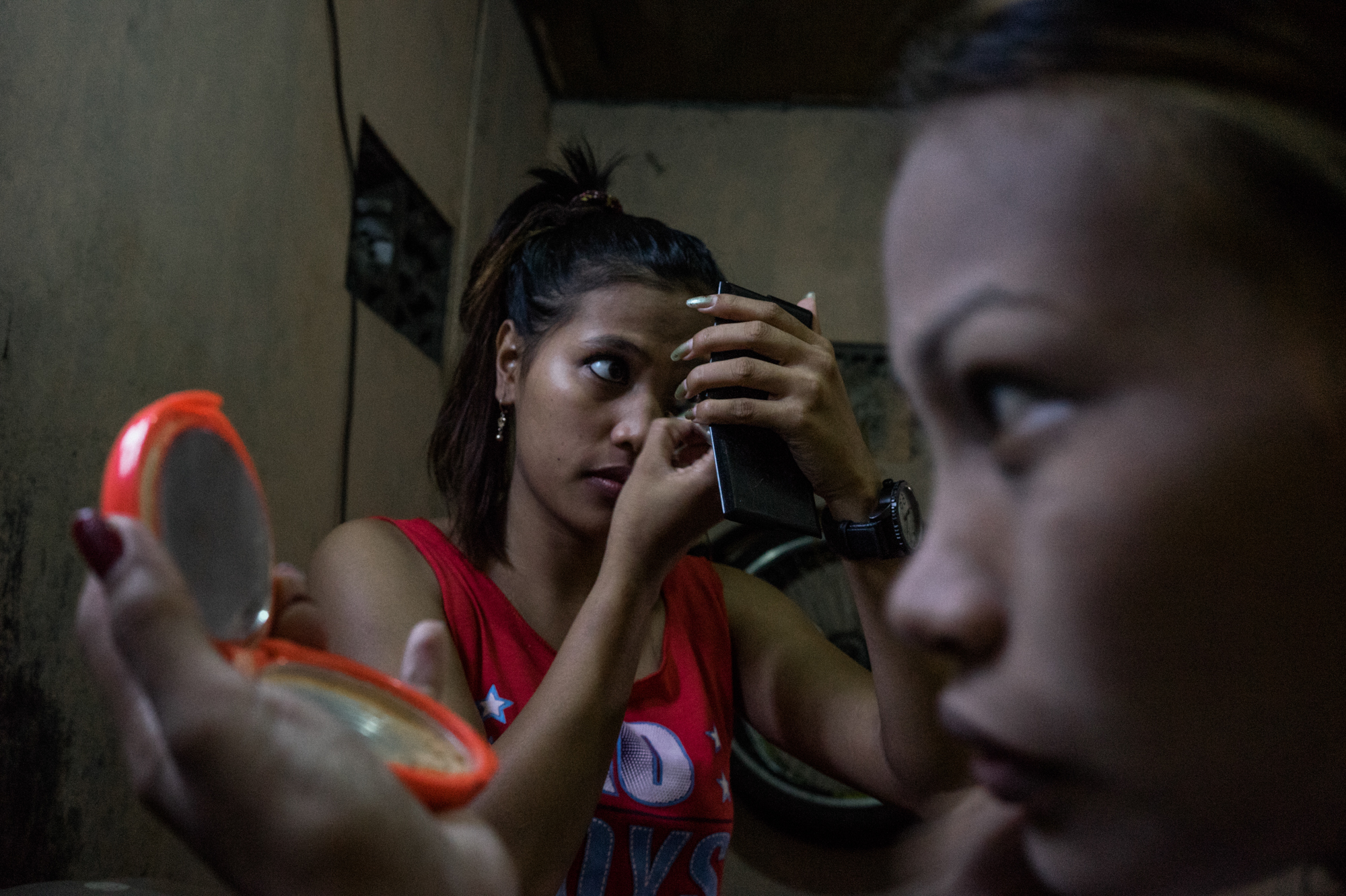 Sisters Gemma and Jojo do their makeup before a night of work in Angeles City, notorious for its sex tourism. (Photo by Hannah Reyes Morales/GroundTruth)