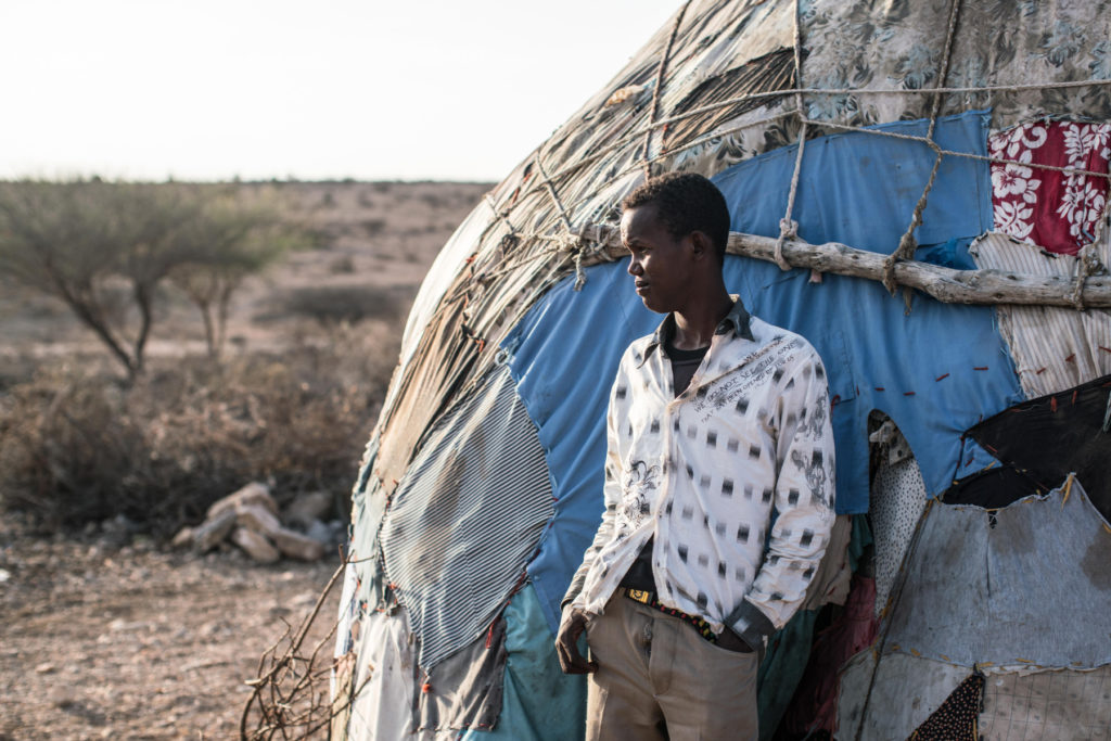 A boy stands outside his family's home at dawn in Gebiley region, Somalia, amidst a severe drought that swept across northwestern Somalia. (Photo by Nichole Sobecki/GroundTruth)