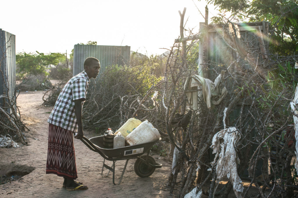 Mohamed Abukar gathers water for his family in Dadaab refugee camp. Mohamed is a refugee who came to Dadaab camp with his wife Habiba and their two daughters during the 2011 drought. (Photo by Nichole Sobecki/GroundTruth)
