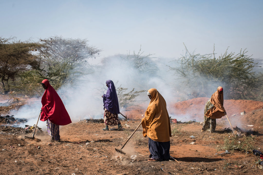 Women burn trash on the roadside in Dadaab refugee camp. In 2011, a severe drought pushed tens of thousands of Somalis from their homes, swelling the camp's population. Host to more than a third of a million people, Dadaab is the world's largest refugee camp, but it's now in danger of being shut down. (Nichole Sobecki/GroundTruth)