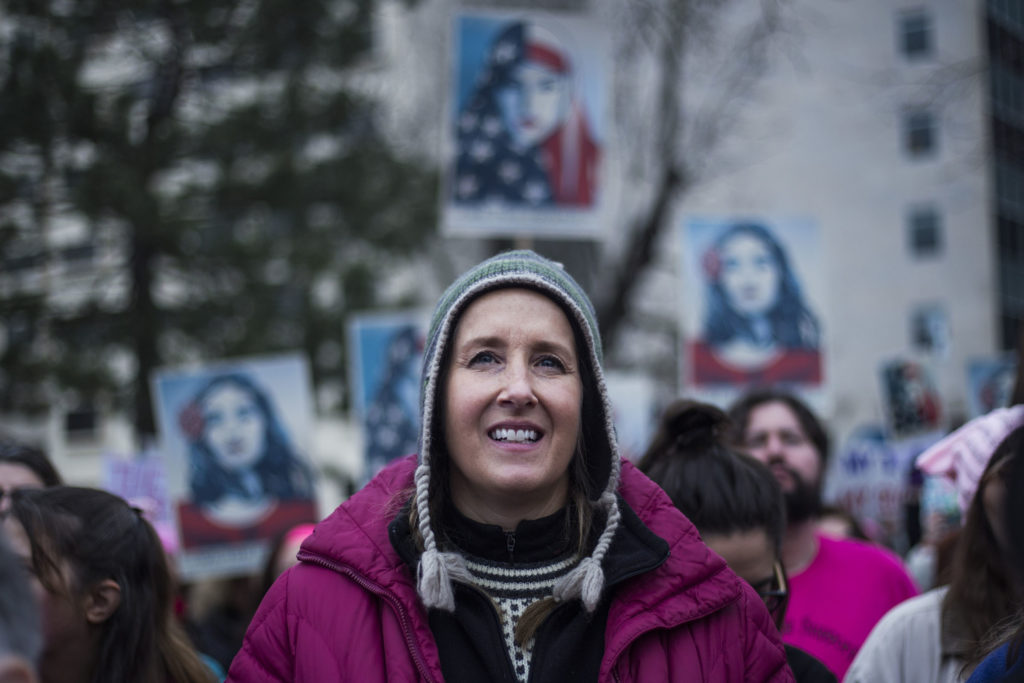Jennifer Day, 49, of Ann Arbor, listens to speakers for the Women's March on Lansing outside of the Michigan State Capitol Building in Lansing, Mich., on Saturday, January 21, 2017. "I'm definitely feeling inspired. I want to put a voice to what kind of change we want to see," Day said. (Photo by Brittany Greeson/GroundTruth)