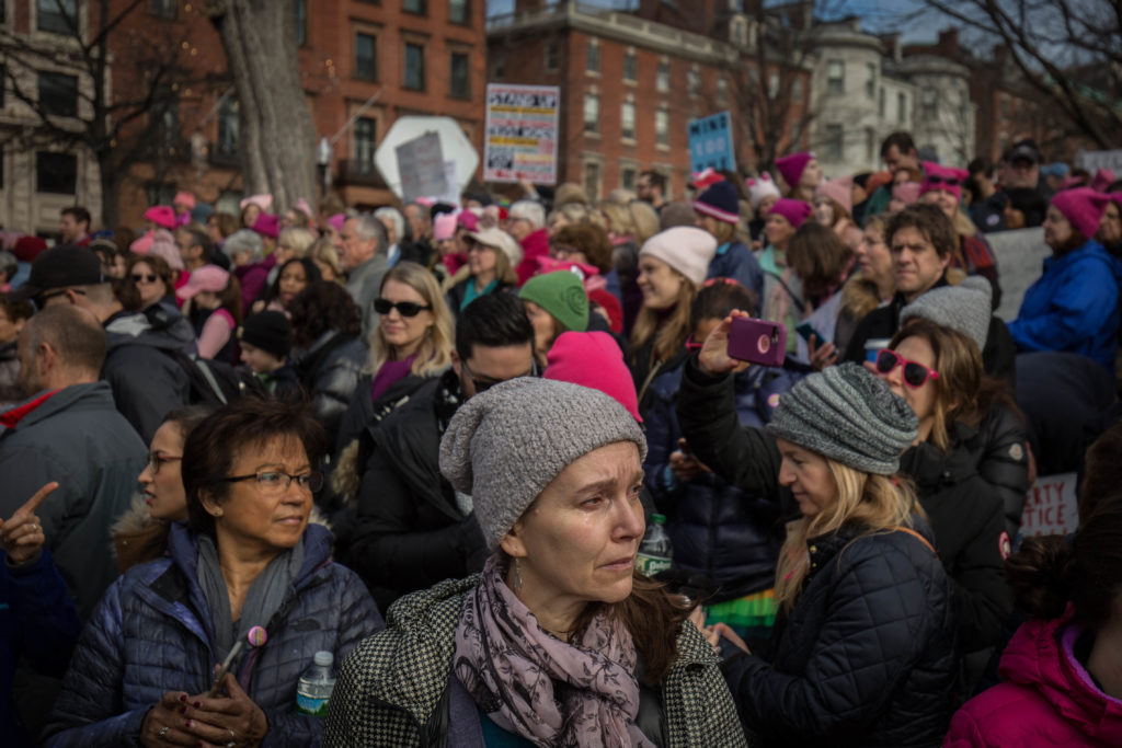 A woman sheds a tear as the song, "America the Beautiful: Together We Stand" plays in the Boston Common during the Boston Women's March on Jan. 21, 2017. (Photo by Alastair J. Pike/GroundTruth)