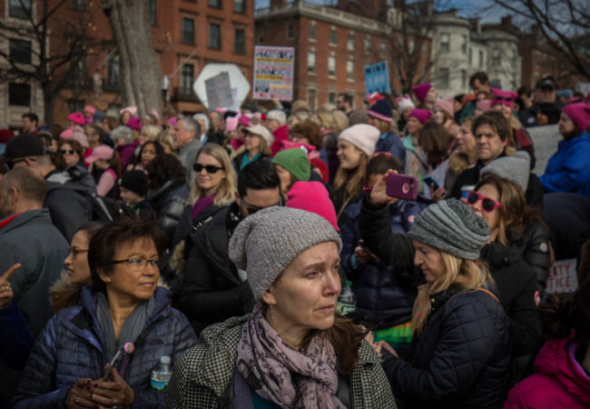 A woman sheds a tear as the song, "America the Beautiful: Together We Stand" plays in the Boston Common during the Boston Women's March on Jan. 21, 2017. (Photo by Alastair J. Pike/GroundTruth)