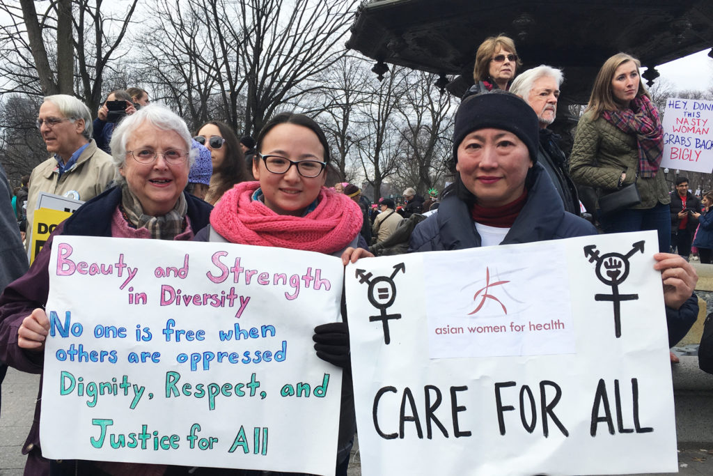 (Left to right) Claris Bergman, Samantha Bergman and Chien-Chi Huang, all part of the same family, explain why they march in Boston on Jan. 21, 2017. (Photo by Kelly Kasulis/GroundTruth)