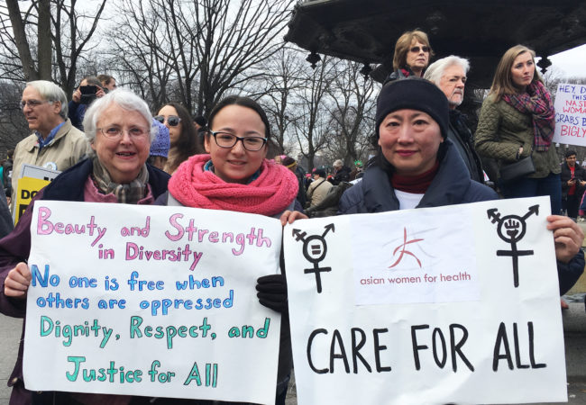 (Left to right) Claris Bergman, Samantha Bergman and Chien-Chi Huang, all part of the same family, explain why they march in Boston on Jan. 21, 2017. (Photo by Kelly Kasulis/GroundTruth)