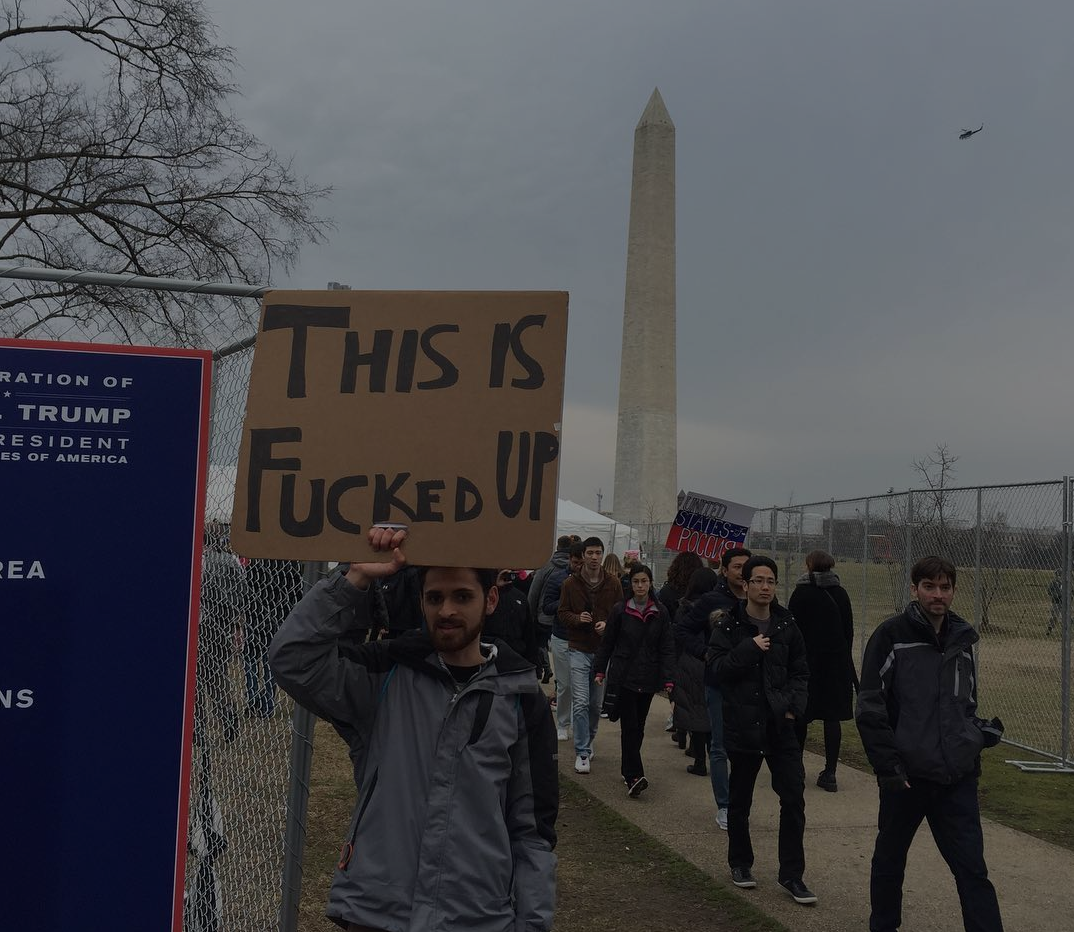McLean stands in front of the Washington Monument holding a sign in protest of Trump's inauguration. (Photo by Kevin D. Grant/GroundTruth)