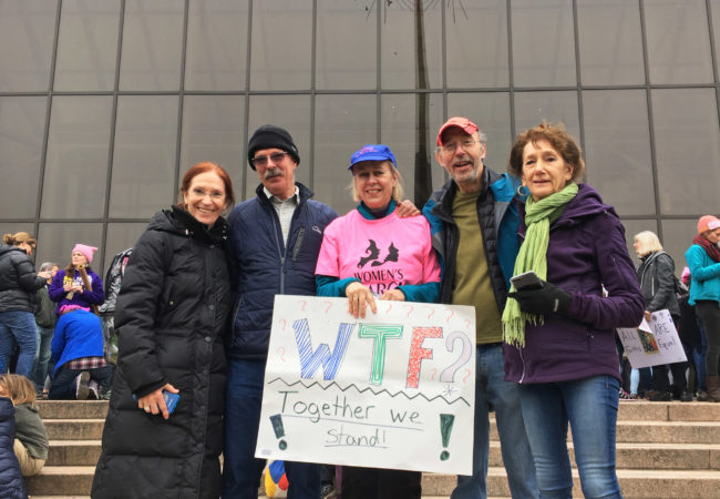 Anna Fierst, the great-granddaughter of Eleanor Roosevelt (center), holds up a sign that says, "Together We Stand." (Photo by Beth Murphy/GroundTruth)