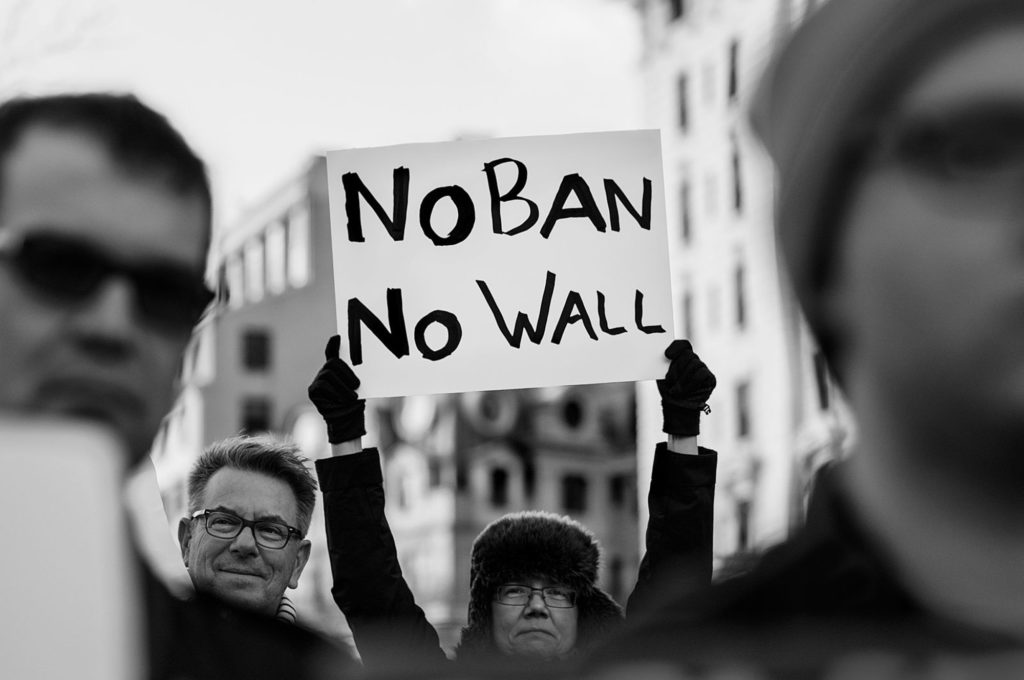 A protester holds up a sign that reads, "No ban, no wall" at a rally against President Trump's "Muslim Ban" on Jan. 26, 2017. (Photo by Lorie Shaull/Wikimedia Commons)