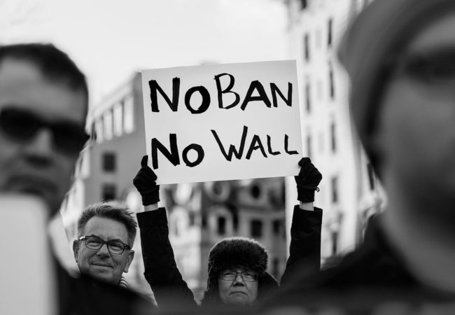 A protester holds up a sign that reads, "No ban, no wall" at a rally against President Trump's "Muslim Ban" on Jan. 26, 2017. (Photo by Lorie Shaull/Wikimedia Commons)