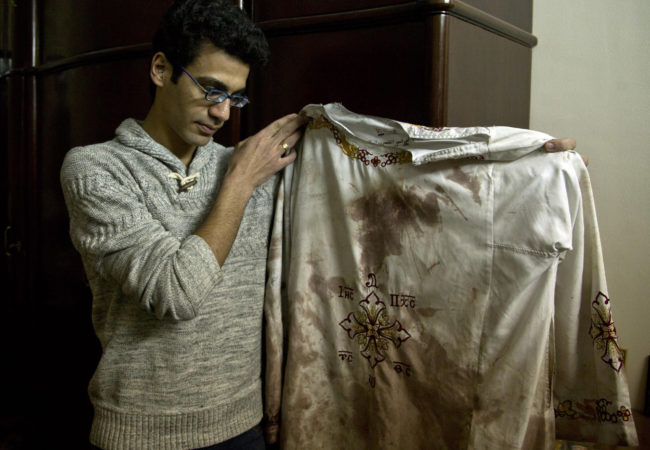 Kirollos is the brother of Bishoy Danial who died in the Palm Sunday suicide bombing in Tanta. He is holding the vestment that his father, Priest Daniel, wore during the attack. Tanta, Egypt, April 12, 2017 (Photo by Roger Anis/GroundTruth)