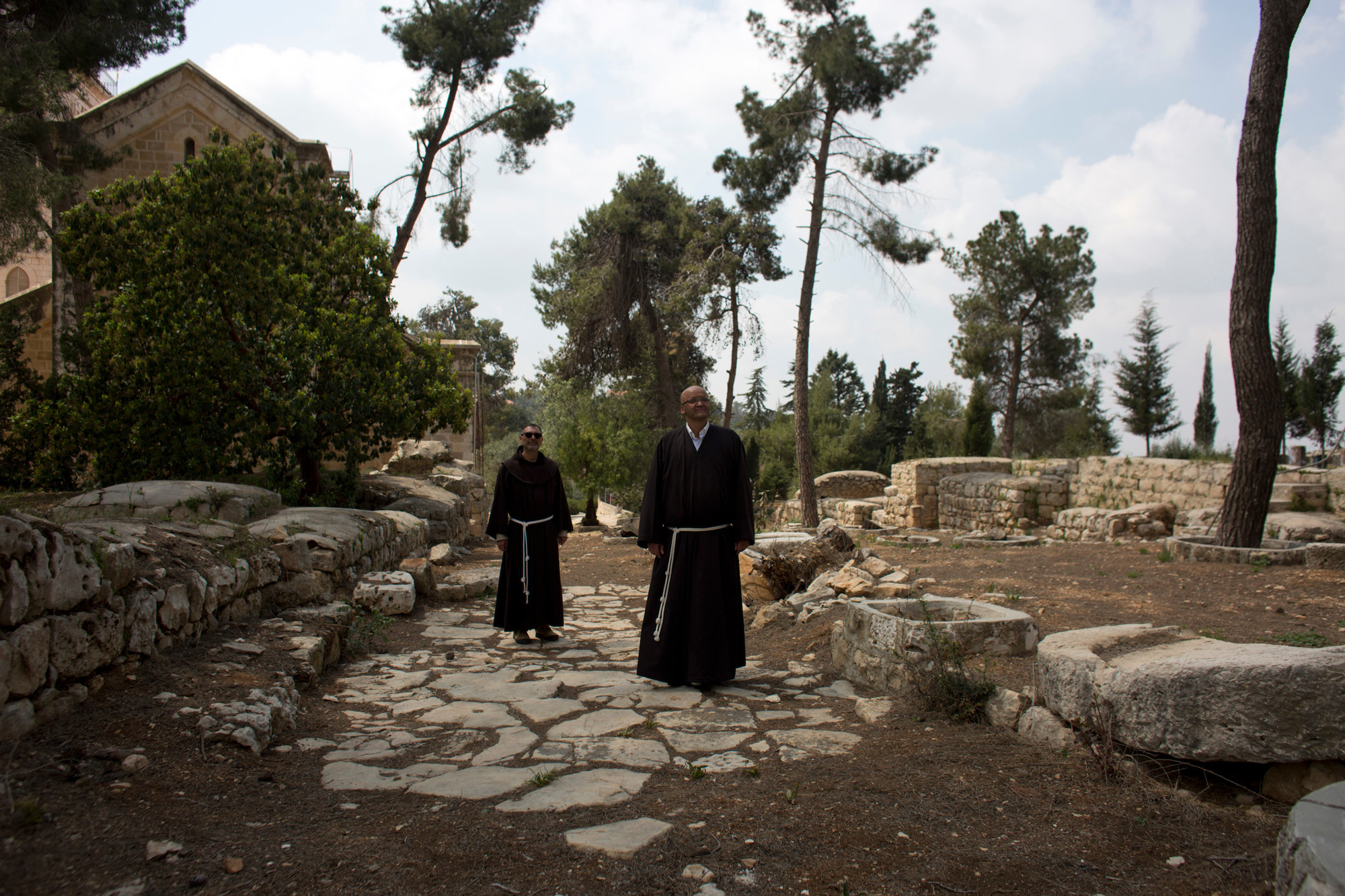 Father Salem Yunis, from Aleppo, Syria, and Father Oscar Rodriguez, from El Salvador, stand on the remnants of an ancient Roman road in Emmaus, which today lies in West Bank territory. (Photo by Heidi Levine/GroundTruth)