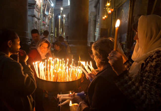 Christian pilgrims light candles during Easter Sunday at the Church of the Holy Sepulchre, traditionally believed by Christians to be the site of the crucifixion and burial of Jesus Christ. Thousands of Christians from across the world flocked to Jerusalem to commemorate Easter. Jerusalem, April 16, 2017 (Photo by Heidi Levine/GroundTruth).