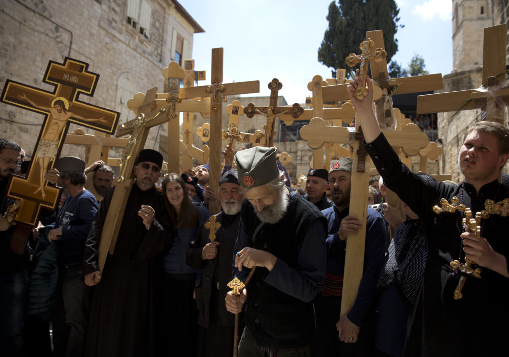 Christian Orthodox pilgrims from Serbia pray and sing, carrying wooden crosses before entering the Church of the Holy Sepulchre on April 14, 2017. (Photo by Heidi Levine)