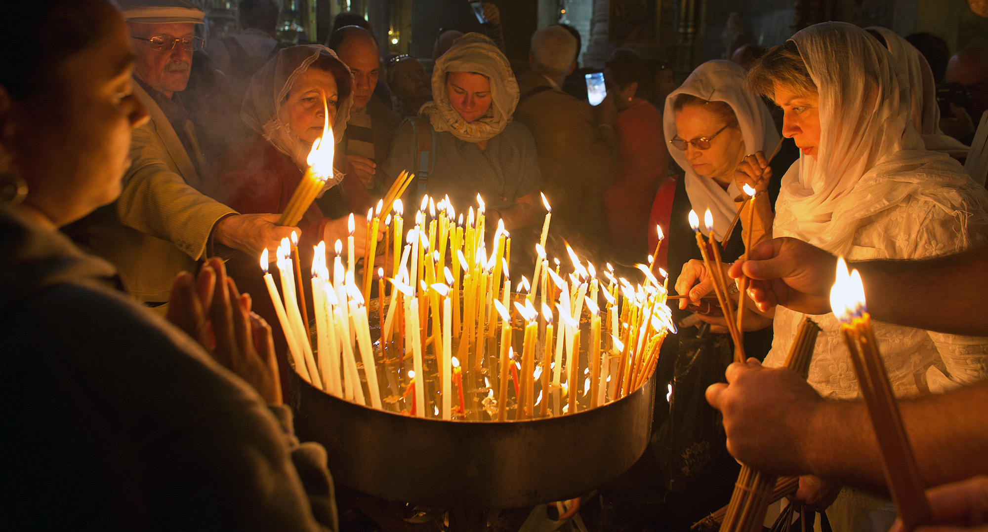 Christian pilgrims light candles during Easter Sunday at the Church of the Holy Sepulchre, traditionally believed by Christians to be the site of the crucifixion and burial of Jesus Christ. Thousands of Christians from across the world flocked to Jerusalem to commemorate the day when, according to Christian tradition, Jesus resurrected. Jerusalem, April 16, 2017 (Photo by Heidi Levine/GroundTruth).