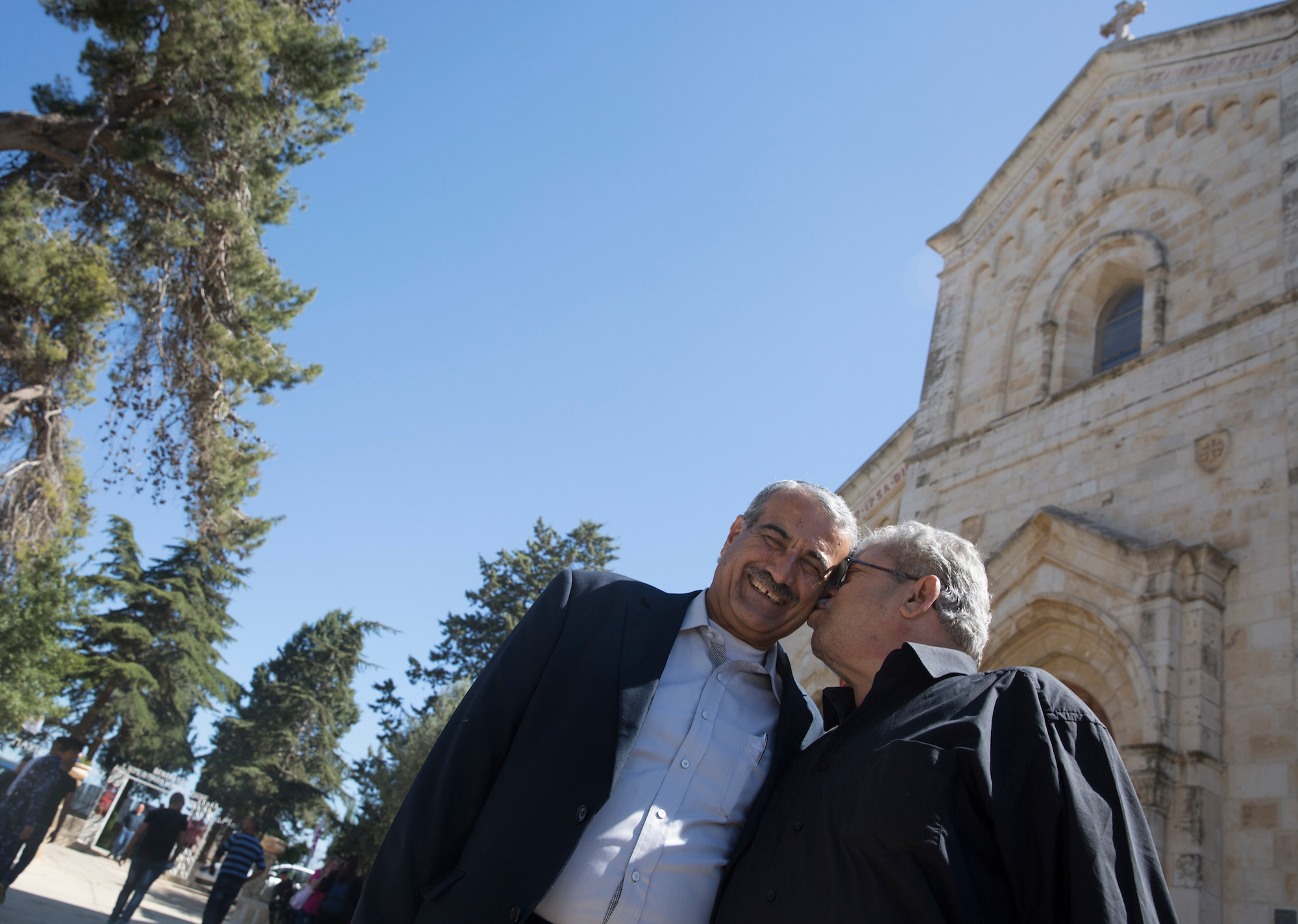 Anton Qulibyoba Yoakim, 63, (R) kisses his friend Baker Ma’Ali, 63, at the Franciscan Church of Emmaus in the West Bank village of El Qubeibeh on Monday, April 17, 2017. Anton recalled how they both breastfed from each other’s mother when they were babies. (Photo by Heidi Levine/GroundTruth)