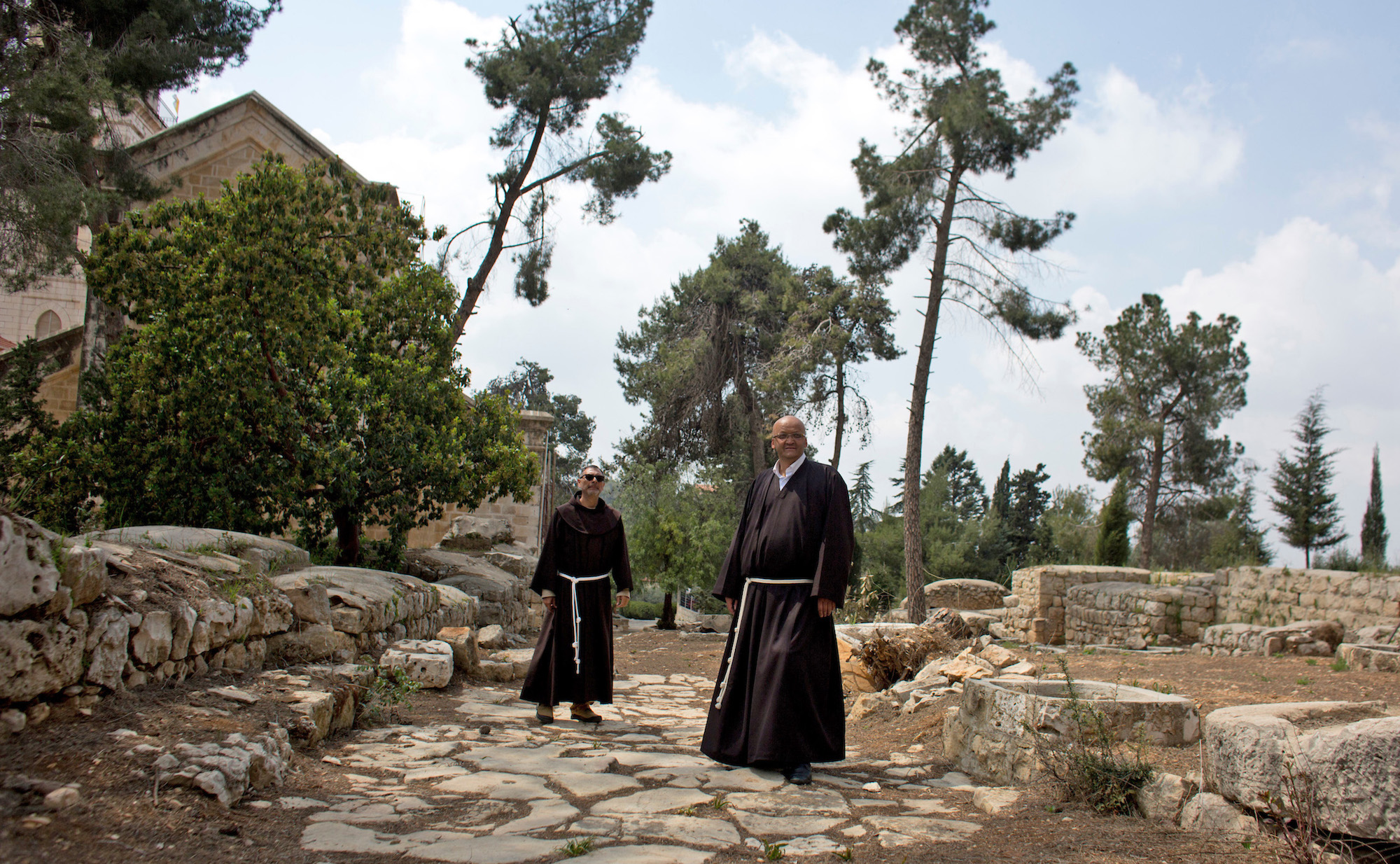 Father Salem Yunis, from Aleppo, Syria (R), and Father Oscar Rodriguez, from El Salvador (L), stand on the remnants of an ancient Roman road in Emmaus, which today lies in West Bank territory.