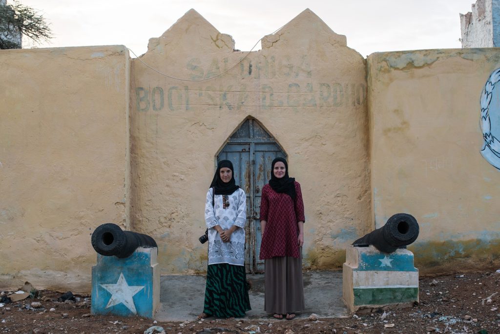 GroundTruth fellows Nichole Sobecki (left) and Laura Heaton (right) stand between two cannons on their reporting trip to Somalia, where they documented links between drought and violent conflict.