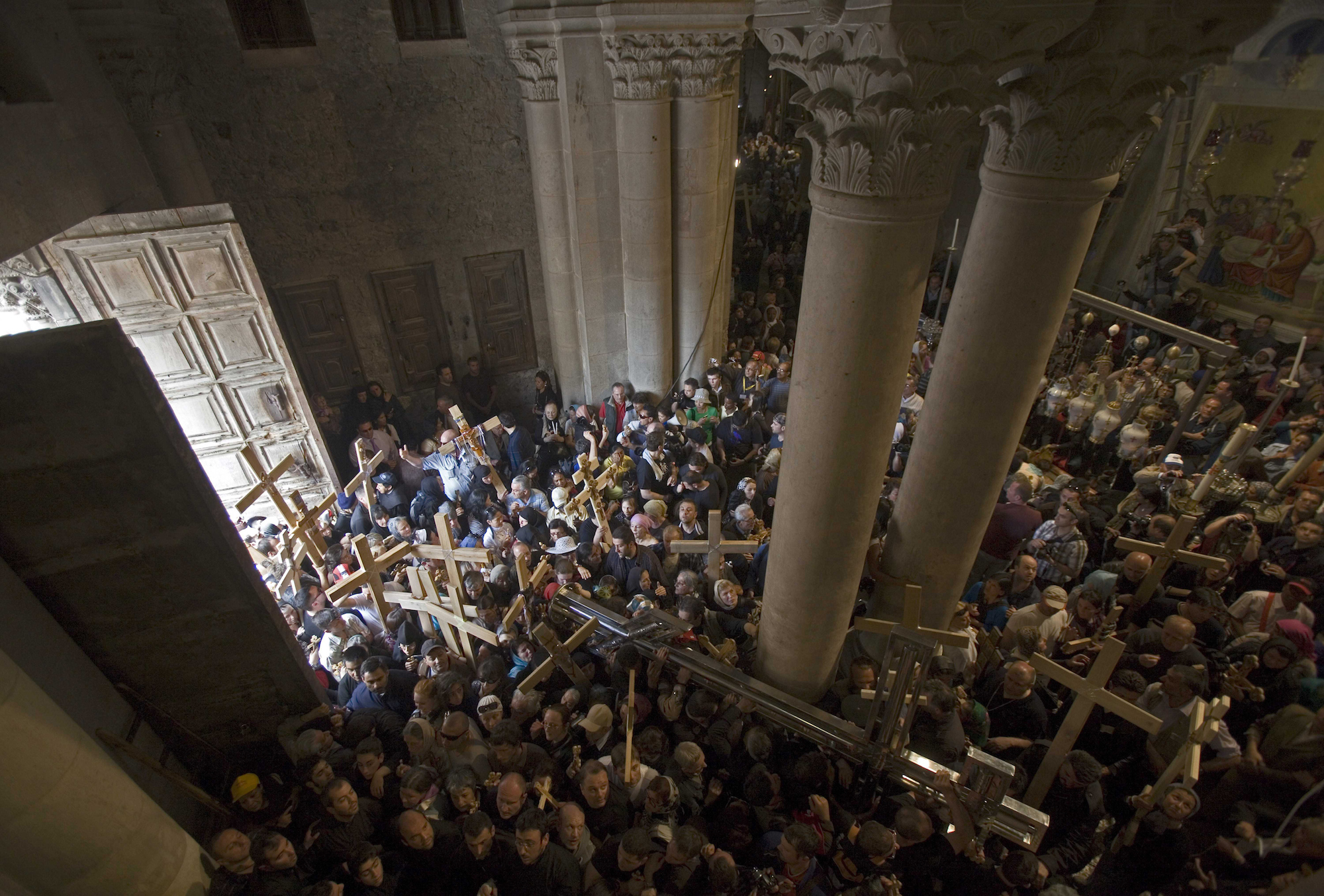 Christian pilgrims carry crosses inside the Church of the Holy Sepulchre during a Good Friday procession in Jerusalem's Old city April 2, 2010. Christian worshippers retraced the traditional route Jesus Christ took along the Via Dolorosa to his crucifixion in the Church of the Holy Sepulchre. (Photo by Heidi Levine/Sipa Press)