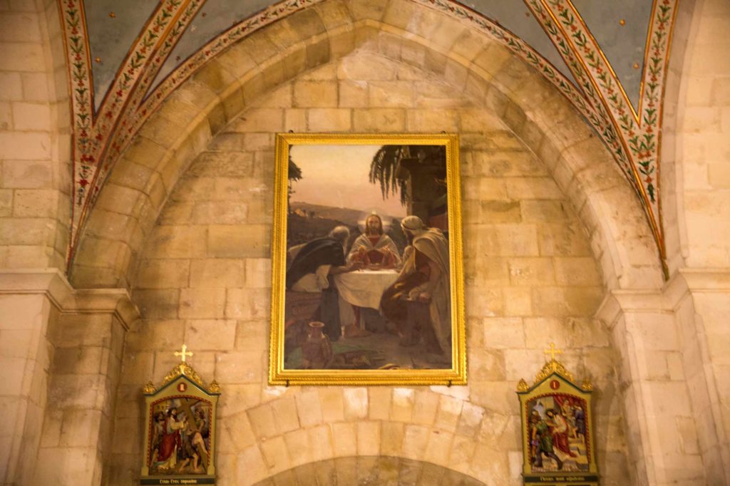 A painting depicts Jesus breaking bread with the disciples Simeon and Cleopias in the biblical town of Emmaus, in the Franciscan Church of Emmaus. El Qubeibeh, April 15, 2017. (Photo by Heidi Levine/GroundTruth)