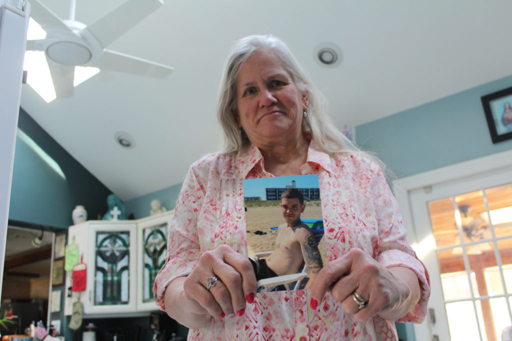 Candace Crupi holds up the photo of her son, Johnny Crupi, who died of a heroin overdose at age 21. (Photo by Noah Caldwell/GroundTruth)