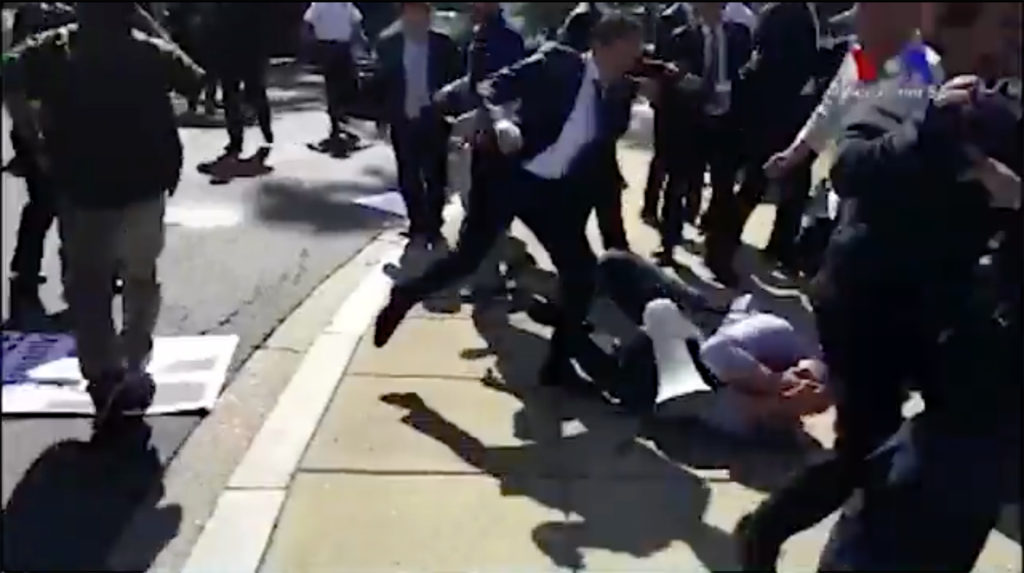In this screenshot from a video posted on Twitter by VOA Turkish, a man can be seen kicking a protester on the ground.
