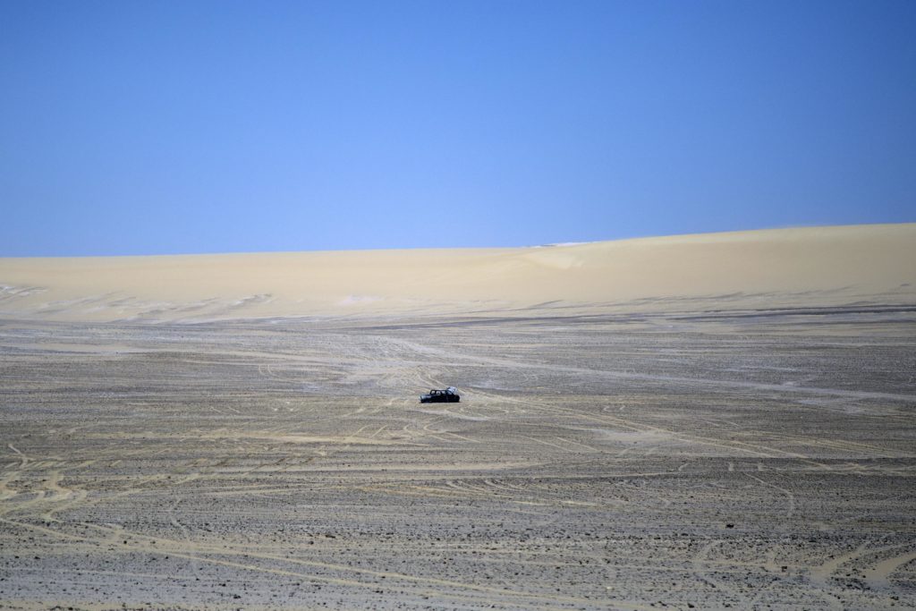 A torched SUV can be seen in the heart of the desert beyond Saint Samuel Monastery, a Coptic Christian church in Minya, Egypt. According to eyewitnesses it belongs to the assailants, who they claim set fire to the vehicle and fled when it got stuck in the sand. (Roger Anis/GroundTruth)